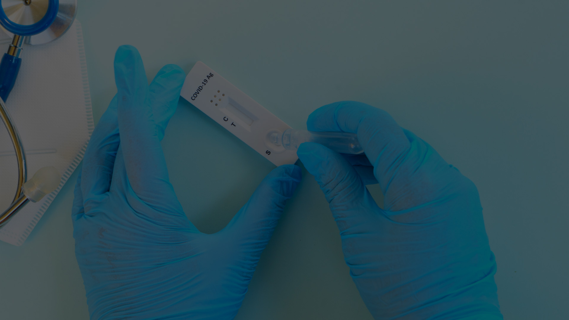 Fotografie a unor maini cu manusi chirurgicale ce manipuleaza un test rapid antigen de depistare al virusului SARS-CoV-2